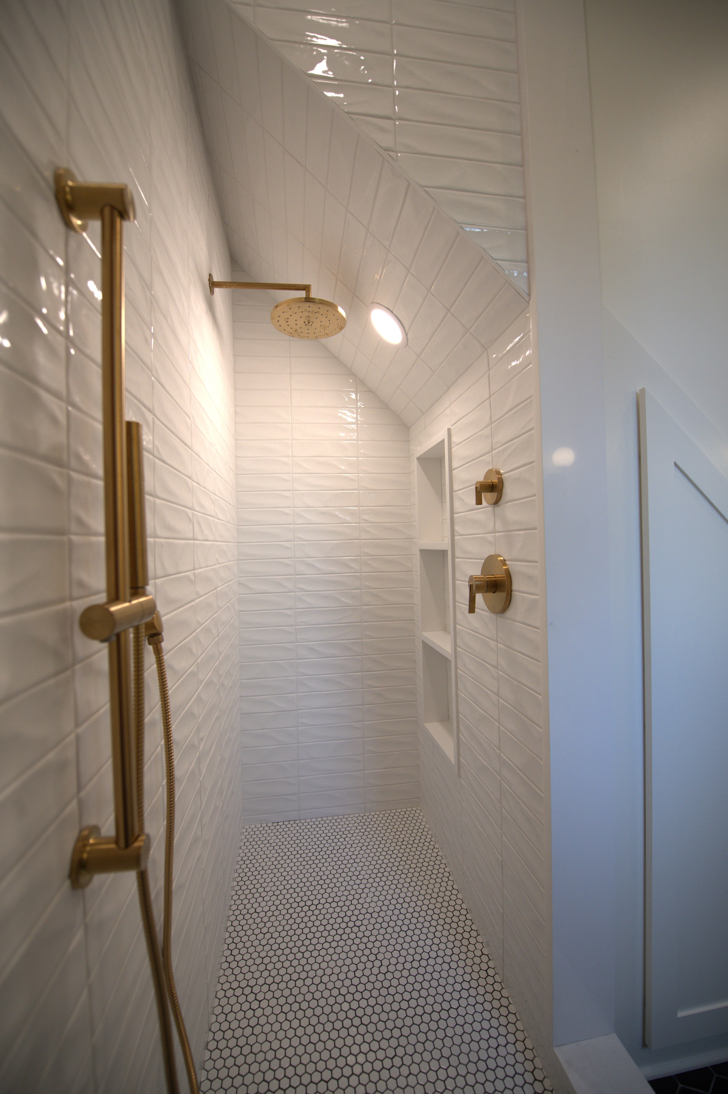 Shower close-up showing tile and brass shower head