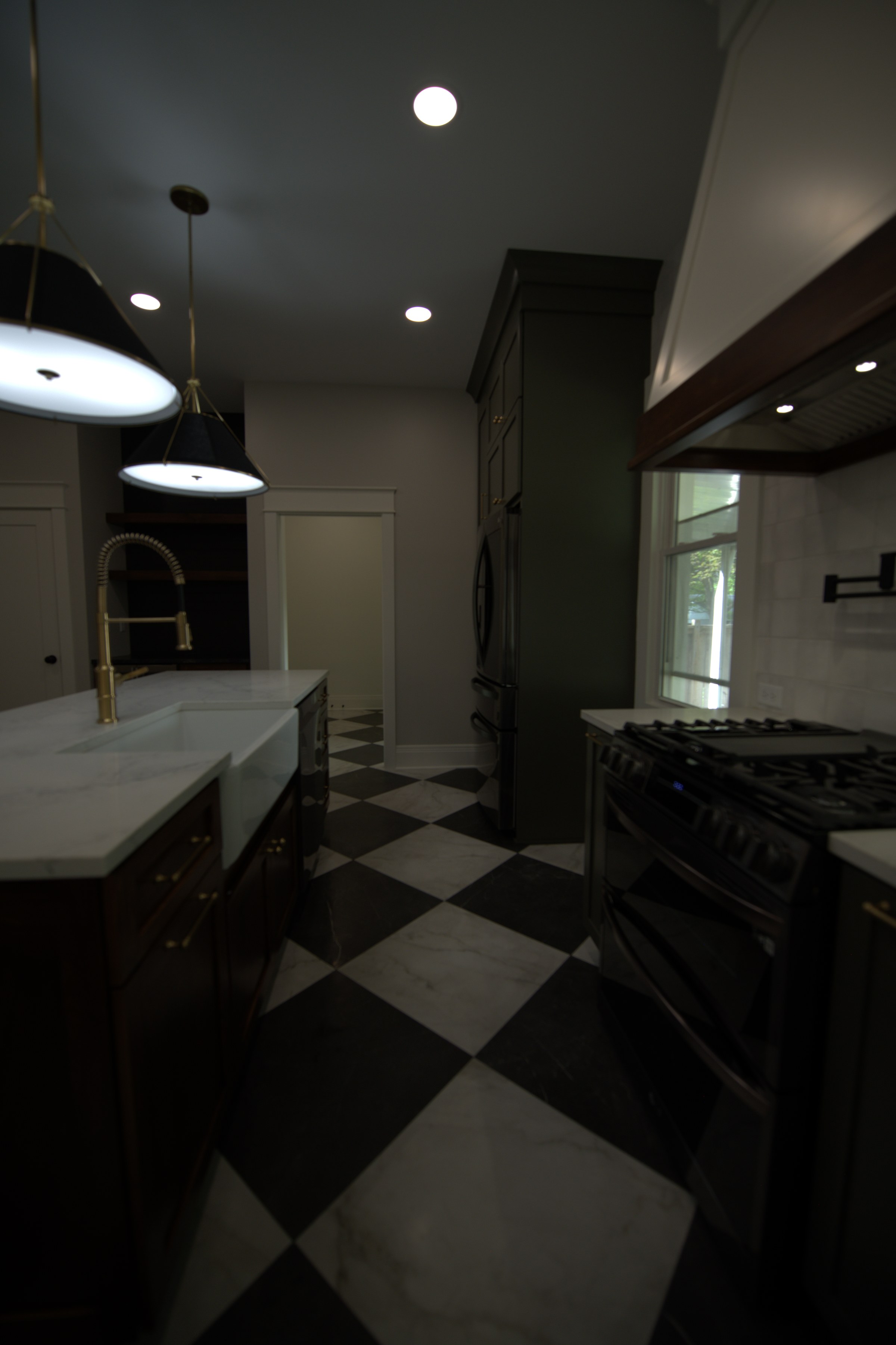 Kitchen with checkered floor, range, dark hood