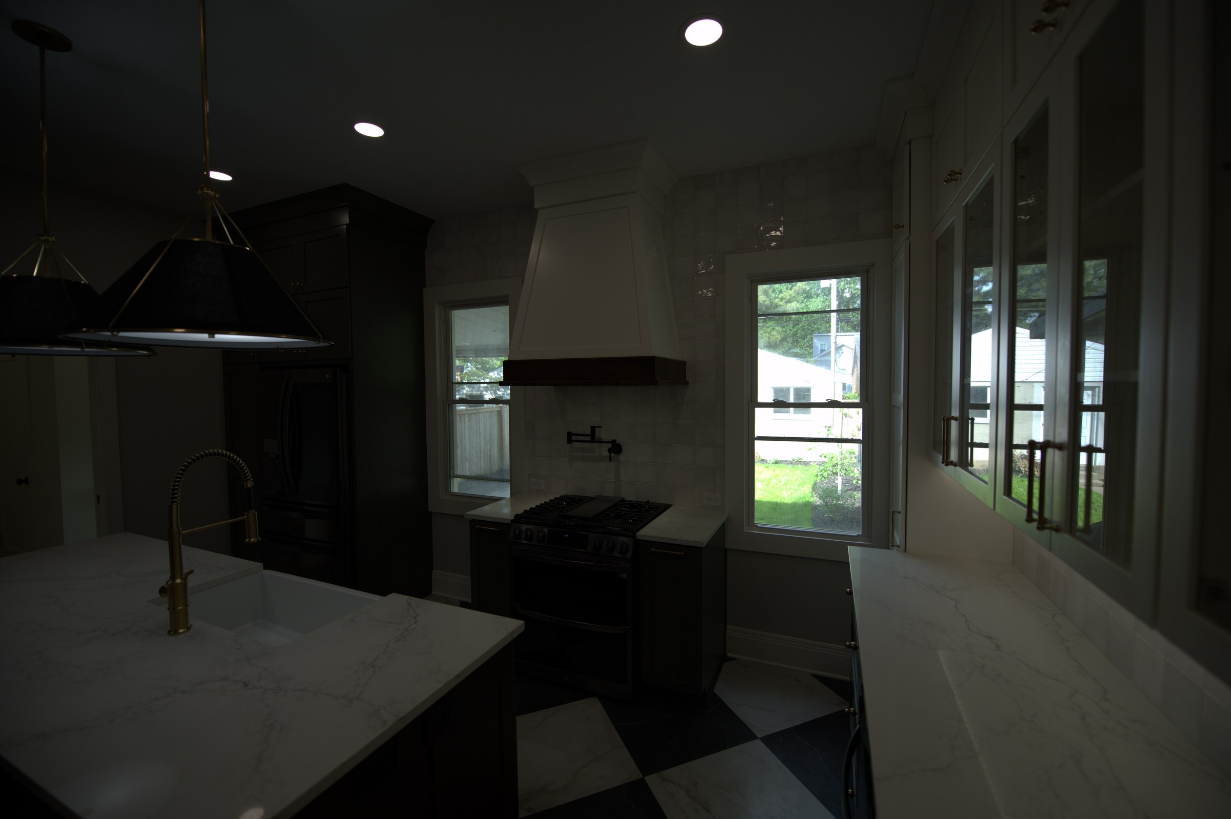 Kitchen looking toward windows, dark cabinetry