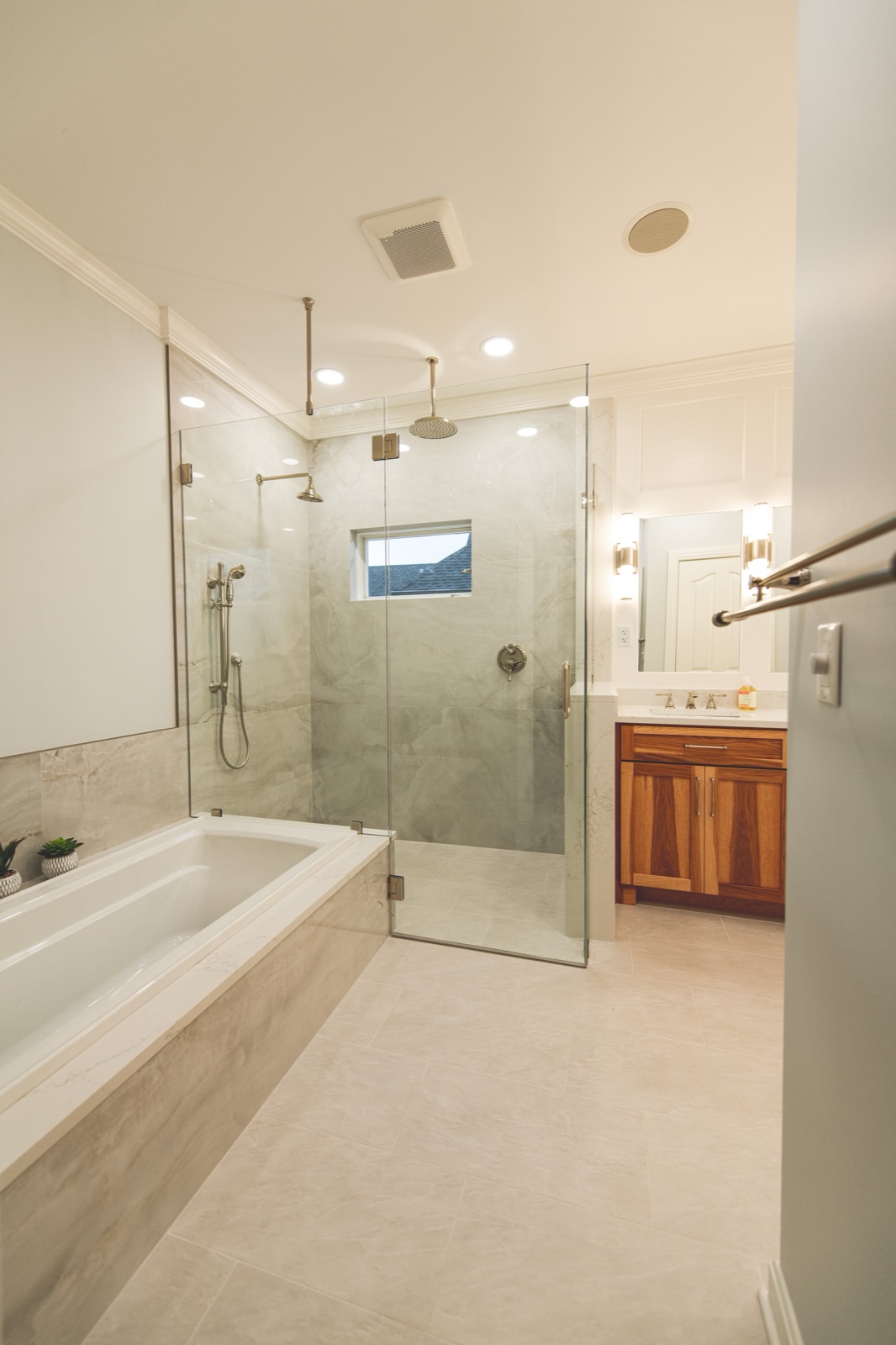 Glass shower enclosure with marble-look tile surround