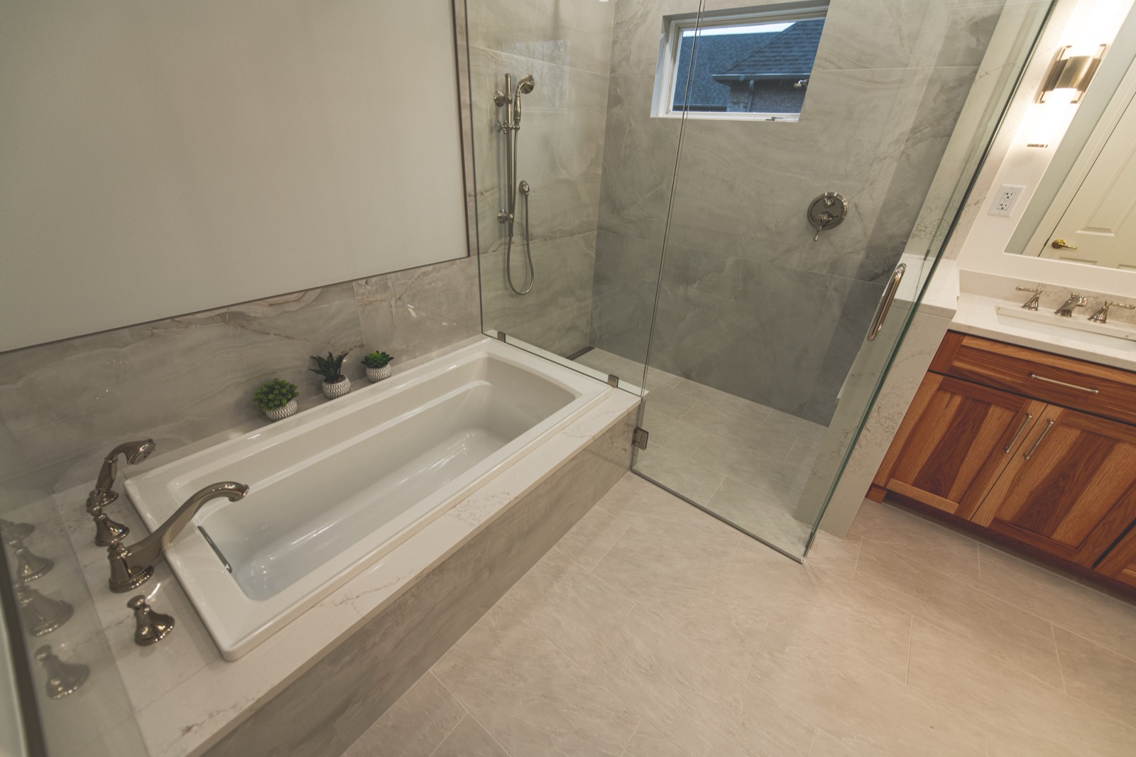 Freestanding soaker tub with glass shower enclosure behind